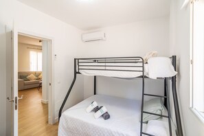 A bunk bed with a mattress and pillows, a rolled towel, and a small table with a chair. - Cubo's Miralmonte Rural House / Private pool / Air conditioning / BBQ (Coín)