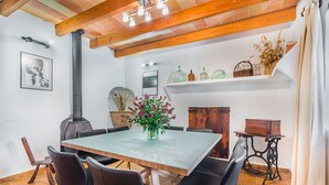 Ein Essbereich mit Tisch, Stühlen, einer Blumenvase und einem Kamin.