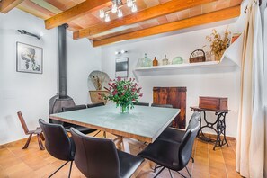 Ein Essbereich mit Tisch, Stühlen, einer Blumenvase und einem Kamin.