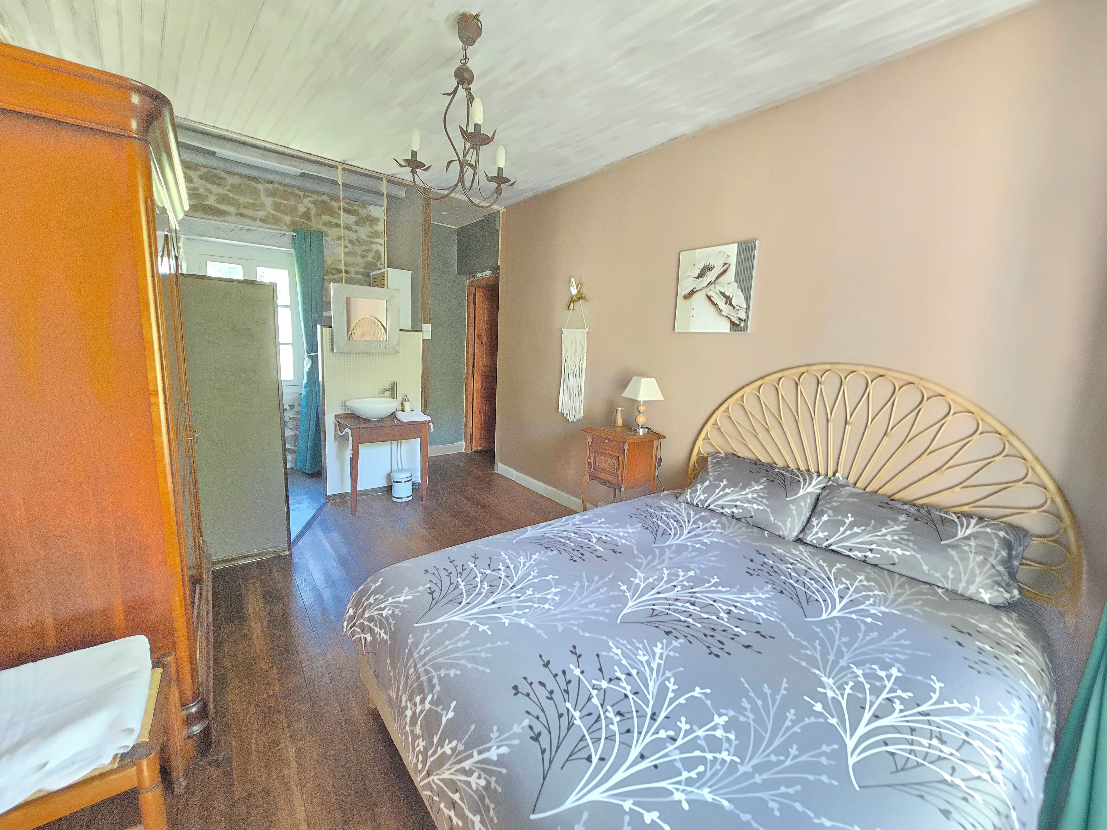 Ein Schlafzimmer mit einem Bett, einem Nachttisch, einer Kommode, einem Spiegel und einer Chandelier.