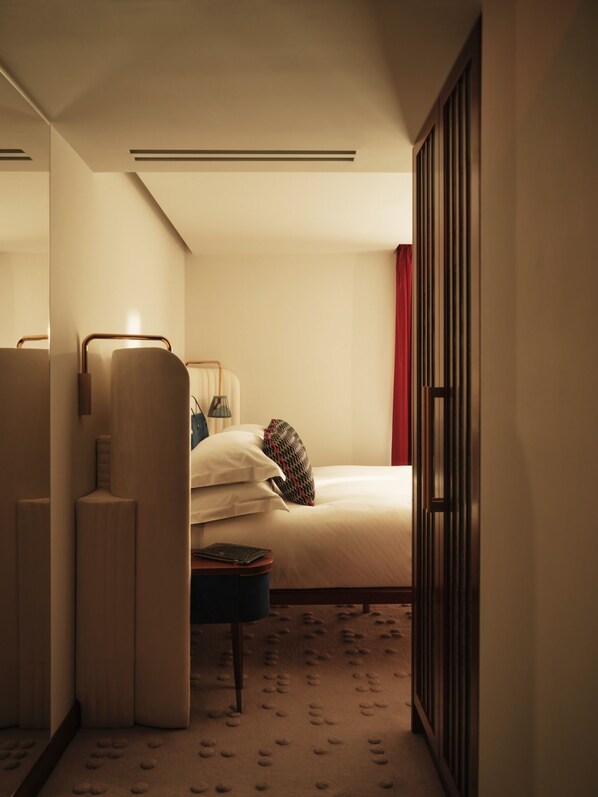 A hotel room with a bed, bedside table, lamp, and a wardrobe. - The Shepherd Mayfair (London)