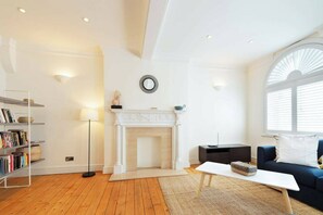 A living room with a fireplace, a bookshelf, a coffee table, and a sofa. - Beautiful 3BDR next to Trafalgar Square - 30+ Days (London)