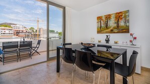 A modern dining area with a view of a construction site through large windows. - Seaside Escape in Cala Sant Vicenc (Pollença)
