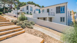 A multi-story residential building with a staircase leading up to the entrance. - Seaside Escape in Cala Sant Vicenc (Pollença)