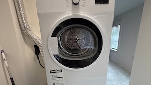 Une machine à laver et un sèche-linge superposés, avec une dosette de lessive Tide posée sur le dessus.