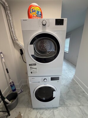 A stacked washer and dryer unit with a Tide detergent pod on top. - Gorgeous 2-bedroom condo with Rooftop deck in downtown Manchester (Manchester)