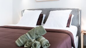 A neatly made bed with a brown bedspread and two white pillows. - Breakwall Retreat - Harrington (Harrington)