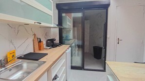 A compact kitchen with a sink, stove, and cabinets. - Modern Studio in Downtown Roubaix With High Speed Internet and Workspace (Roubaix)