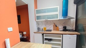 A compact kitchen with a wooden countertop, a small refrigerator, and a built-in oven. - Modern Studio in Downtown Roubaix With High Speed Internet and Workspace (Roubaix)
