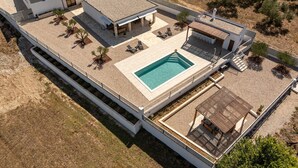 Ein modernes Wohnhaus mit Dachpool, Sitzgelegenheiten im Freien und einer überdachten Terrasse.