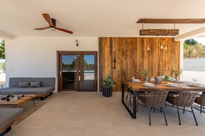 An outdoor patio with a dining table set for four, a sofa, and a ceiling fan. - Villa Casa Olea ZadarVillas (Perušic Benkovacki)