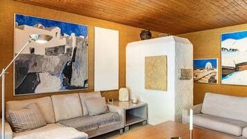 Una sala de estar moderna con un sofá, una mesa de centro y obras de arte en las paredes.