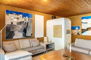 Un salon moderne avec un canapé, une table basse et des œuvres d’art accrochées aux murs.