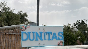 Une enseigne portant le mot « DUNITAS » est fixée à la façade d’un immeuble.