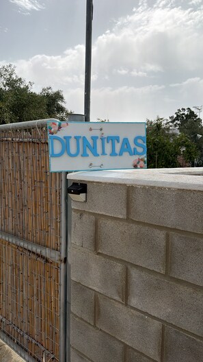 Une enseigne portant le mot « DUNITAS » est fixée à la façade d’un immeuble.