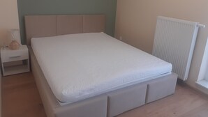 Ein Schlafzimmer mit einem Bett, einem Nachttisch und einer Heizung.