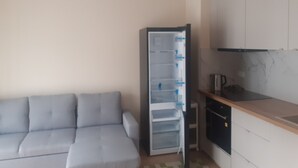 Eine Küchenzeile mit Kühlschrank, Herd und Spüle.