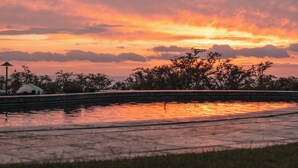 A sunset over a body of water with trees and a lamp post in the foreground. - Hula Hula Ranch - 7 Bedrooms, Pool, Ocean View! (Kamuela)