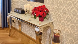 A room with a table, candles, a potted plant, and a framed artwork on the wall. - Sophies Place Augarten (Wien)
