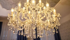A chandelier with multiple arms and crystal decorations. - Sophies Place Augarten (Wien)