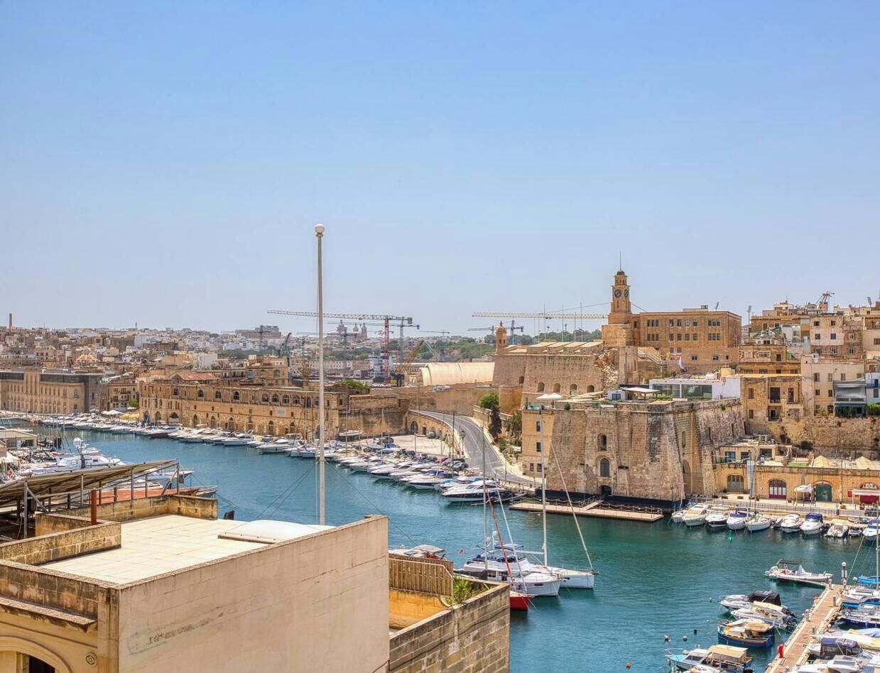 A harbor with boats, a prominent tower, and historic buildings.