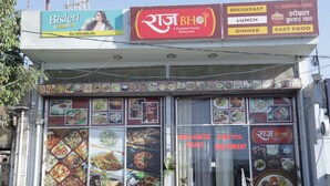 A restaurant with a signboard advertising breakfast, lunch, dinner, and fast food.