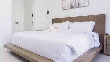 Un dormitorio moderno con una cama grande, una mesita de noche y un cuadro en la pared.