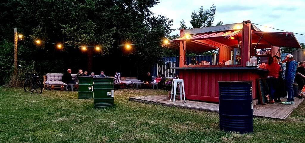 An outdoor bar area with seating, string lights, and a wooden deck.