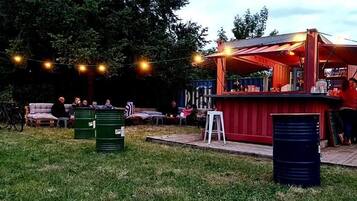 An outdoor bar area with seating, string lights, and a wooden deck.