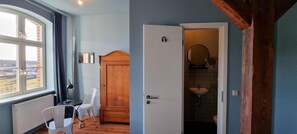 A room with a window, a door leading to a bathroom, and a wooden chair. - An den Wiesen. Gasthaus am Finowkanal (Wandlitz)