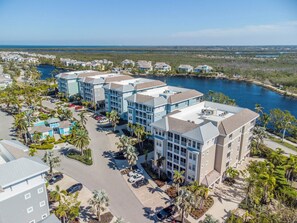 A coastal hotel complex with multiple buildings, a marina, and a view of the ocean. - One Particular Harbour Lagoon View 391-203 · Pet-Friendly (Bradenton)