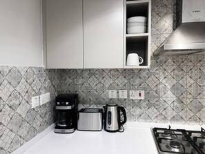 Eine Küche mit Gaskochfeld, Kaffeemaschine, Toaster und Wasserkocher.