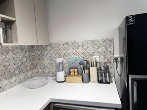 Eine Küche mit Mixer, Messerblock und Kühlschrank.