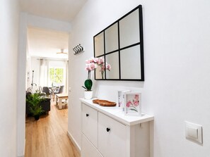 A hallway with a white console table, a potted plant, and a framed mirror. - 1021 Apartment Morasol (Nerja)