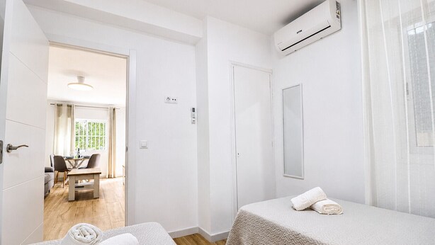 Ein Hotelzimmer mit zwei Betten, einem Essbereich und einer Klimaanlage.