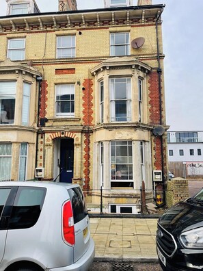 A multi-story building with a traditional architectural style, featuring a corner entrance and multiple windows. - Seaside Escape Lowestoft | Stylish Coastal Stay (Kirkley)