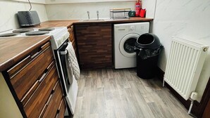 Una cocina compacta con tragaluz, lavadora y estufa.