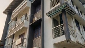 Um edifício de vários andares com varandas, aparelhos de ar condicionado e um telhado plano.