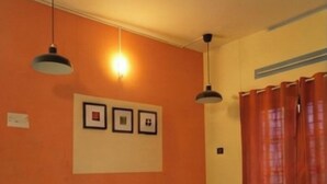 Quarto com sofá, quadro na parede e cortina.