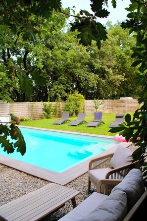 A swimming pool with lounge chairs and a wooden deck. - A Haven of Peace in the South C1S (Vernègues)