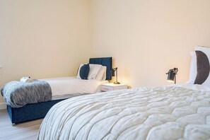 Une chambre d’hôtel avec un lit, des tables de chevet et une lampe.