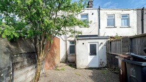 A small, enclosed outdoor area with a door, a gravel ground, and a tree. - Rishton Stay | Shops & Transport | Near Blackburn (Lancashire)