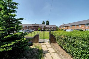 A residential area with houses, a gated entrance, and parked cars. - Wythenshawe Stay | Airport & Hospital | Parking (Greater Manchester)