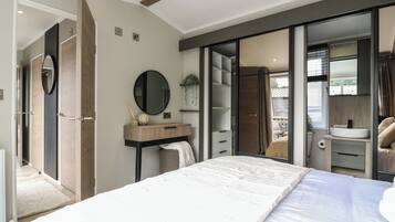 Un dormitorio moderno con una cama grande, una mesita de noche, un espejo y un armario con puertas correderas.