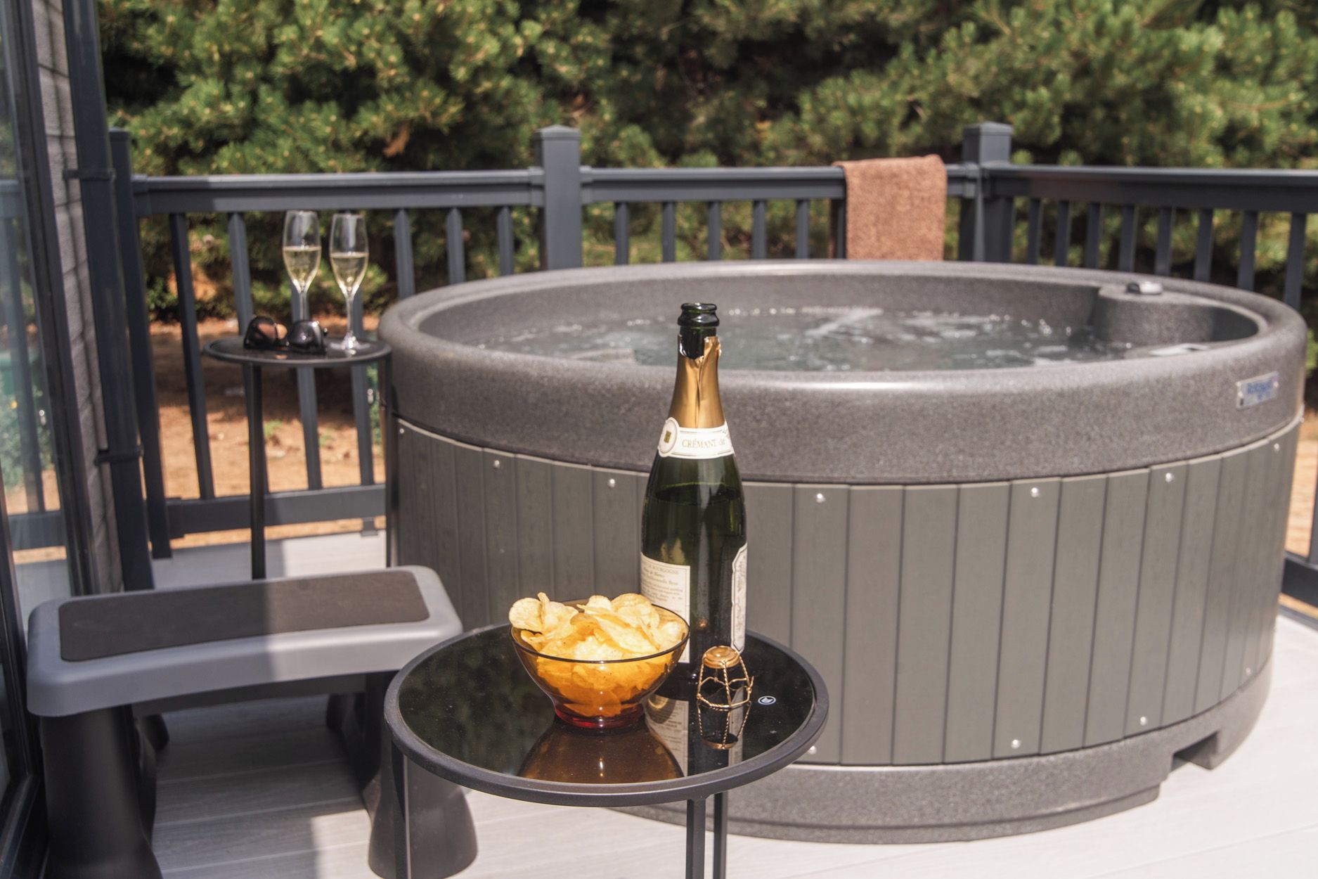 Ein Whirlpool mit einer Champagnerflasche und einer Schüssel Chips auf einem Tisch.