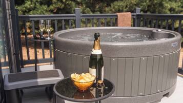 Ein Whirlpool mit einer Champagnerflasche und einer Schüssel Chips auf einem Tisch.