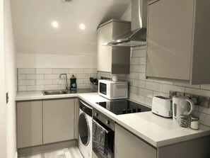 A compact kitchen with a dishwasher, microwave, toaster, and kettle. - Manchester Base | Heaton Park & Shops | Parking (Harpurhey)