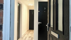 Un passadís amb portes numerades 2 i 3 que condueixen a habitacions.