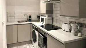 Cuina compacta amb rentaplats, microones, torradora i bullidor.