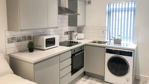 Una cucina compatta con forno a microonde, forno e lavastoviglie.